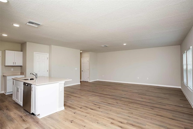 kitchen featuring stainless steel dishwasher, sink, a center island with sink, white cabinets, and light hardwood / wood-style floors