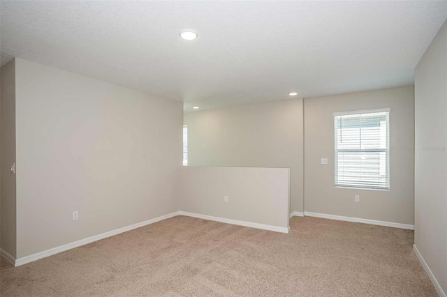 unfurnished room featuring light carpet