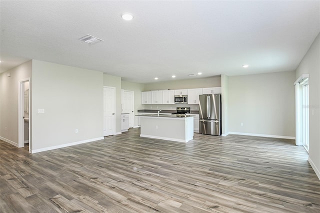 unfurnished living room with a textured ceiling and light wood-type flooring