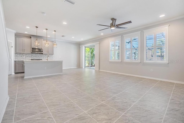 unfurnished living room with ceiling fan, ornamental molding, and light tile patterned flooring