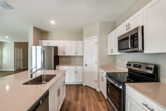 kitchen with white cabinetry, hardwood / wood-style floors, sink, and appliances with stainless steel finishes