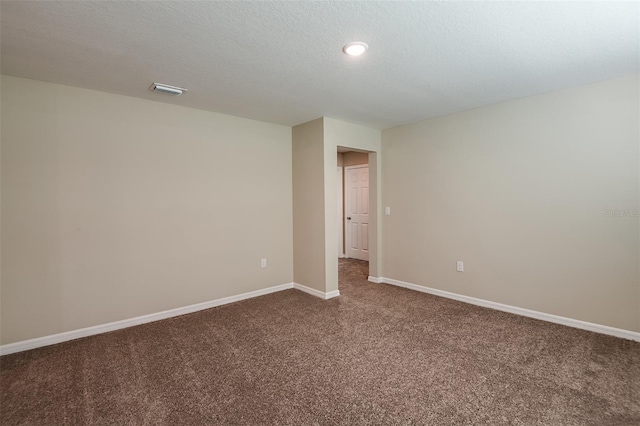 carpeted empty room with a textured ceiling