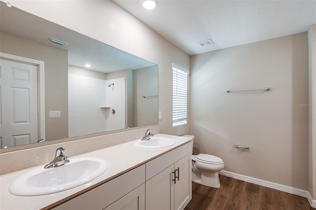 bathroom with vanity, hardwood / wood-style flooring, toilet, and walk in shower