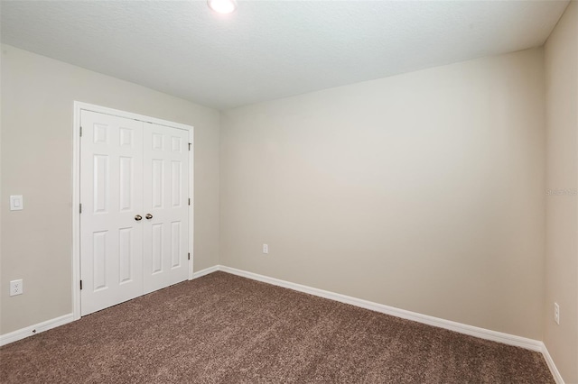 unfurnished bedroom featuring carpet, a textured ceiling, and a closet