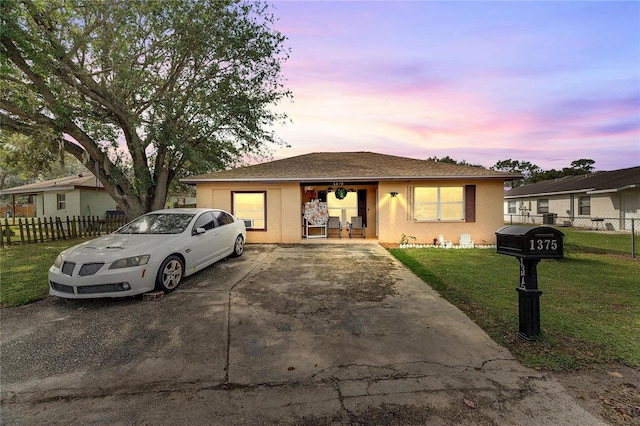 ranch-style home with a yard and covered porch