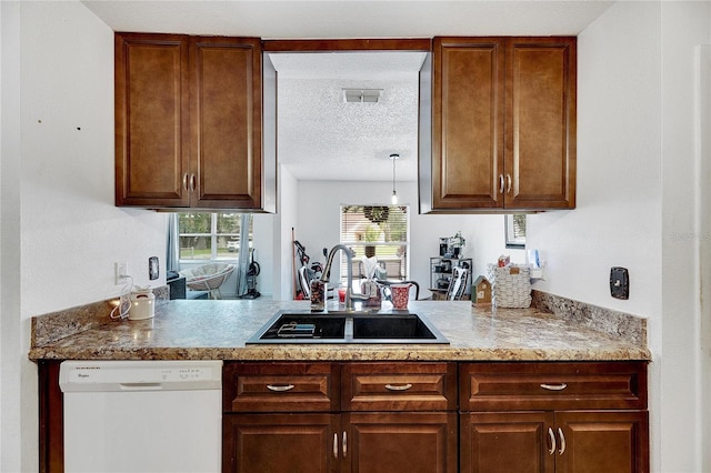 1375 6 Iron Dr, Lakeland, FL 33801 - kitchen featuring white dishwasher, a sink, a textured ceiling, and a peninsula
