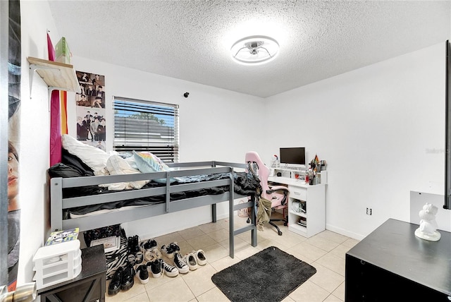 bedroom featuring light tile patterned flooring and a textured ceiling