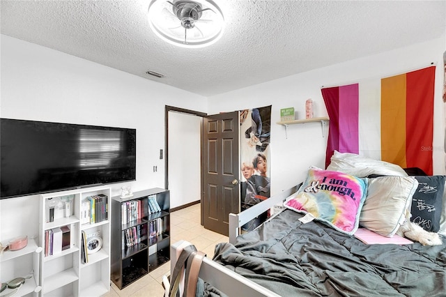 bedroom featuring light tile patterned floors and a textured ceiling