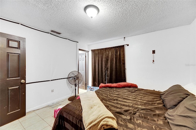 tiled bedroom featuring a textured ceiling