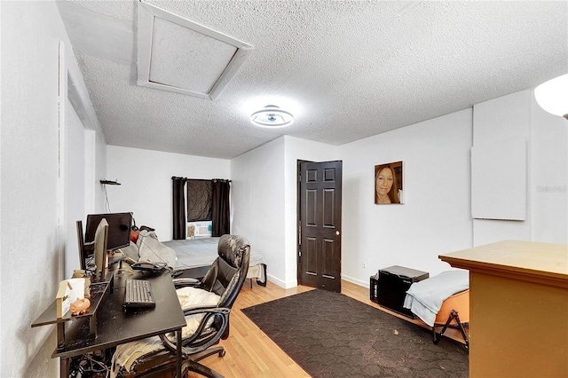 bedroom with a textured ceiling and light hardwood / wood-style floors