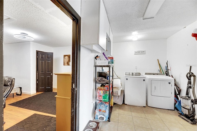 washroom featuring washer and clothes dryer, light hardwood / wood-style floors, and a textured ceiling