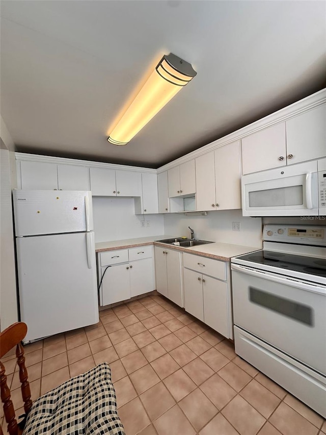 kitchen with sink, white cabinets, white appliances, and light tile patterned floors