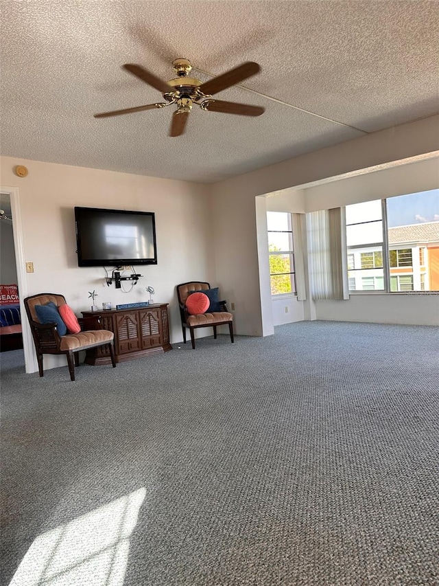 sitting room featuring carpet, a textured ceiling, and ceiling fan