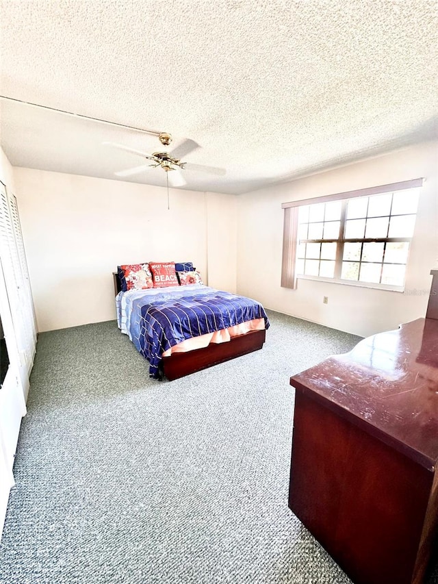 bedroom with carpet flooring, ceiling fan, and a textured ceiling