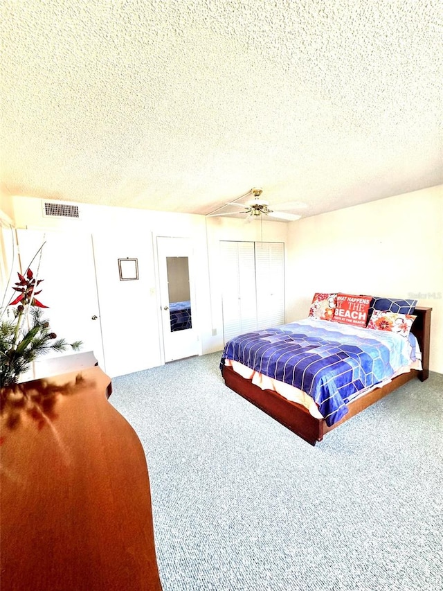 bedroom featuring a textured ceiling, carpet floors, and ceiling fan