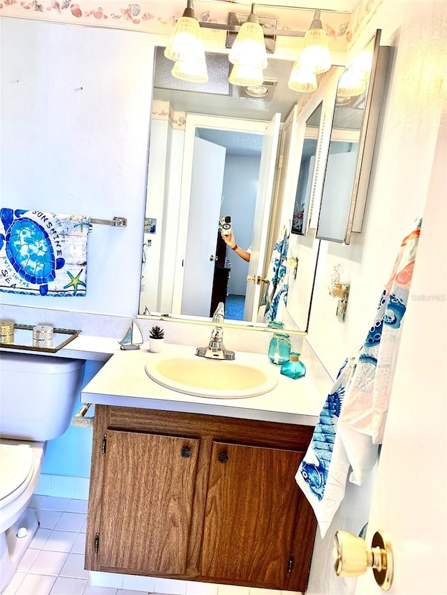 bathroom with tile patterned flooring, vanity, and toilet