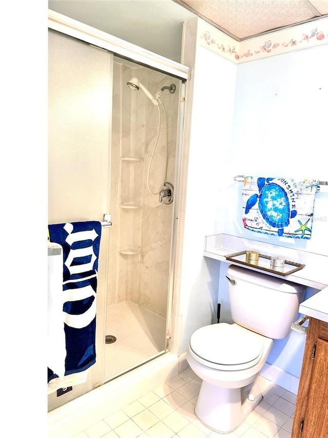 bathroom with tile patterned flooring, a shower with shower door, and toilet