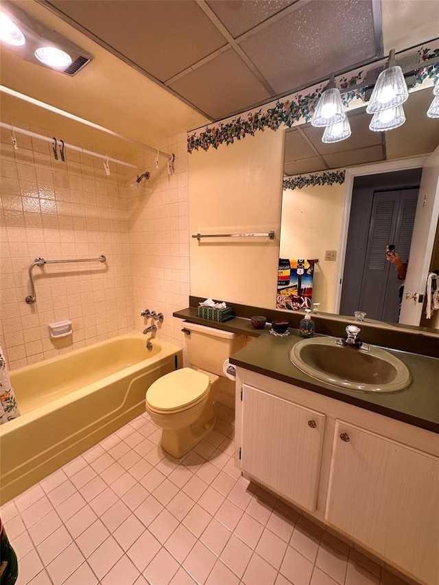 full bathroom with tile patterned floors, vanity, tiled shower / bath combo, and toilet