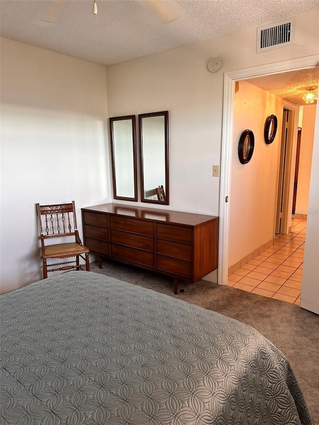 bedroom with light carpet and a textured ceiling