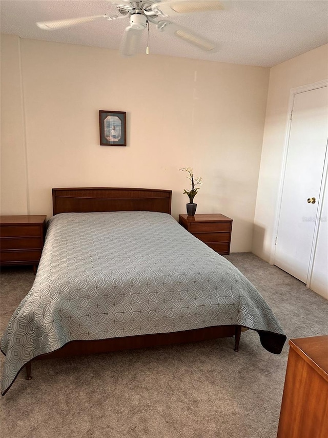 bedroom featuring carpet flooring, ceiling fan, and a textured ceiling