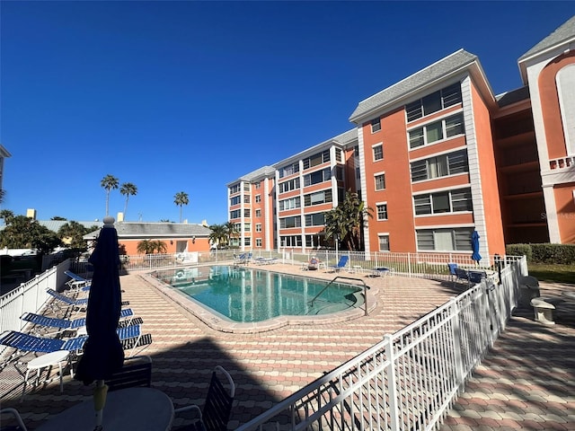 community pool featuring fence and a patio area