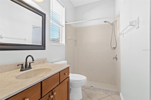 bathroom featuring tile patterned flooring, vanity, tiled shower, and toilet