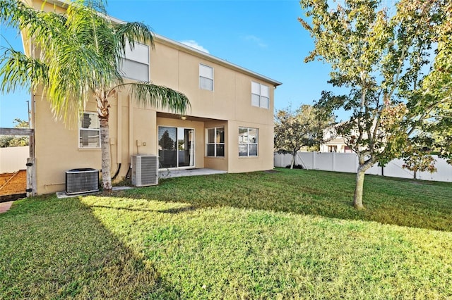 back of property featuring a lawn and central AC