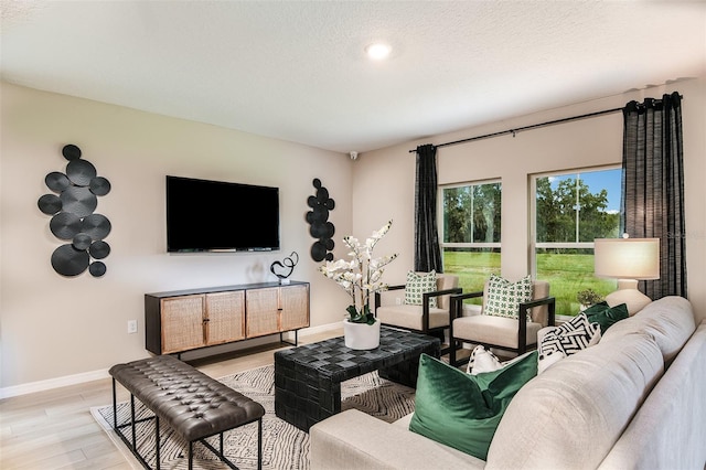 living room with a textured ceiling and light wood-type flooring