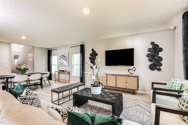 living room with light wood-type flooring and a textured ceiling