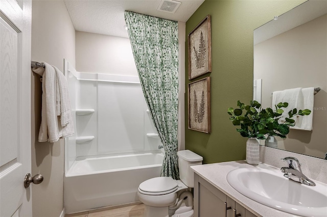 full bathroom featuring shower / bath combination with curtain, toilet, a textured ceiling, and vanity