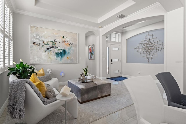 living room featuring a raised ceiling and ornamental molding