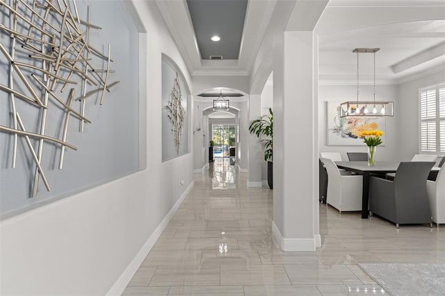 hall with crown molding and a chandelier