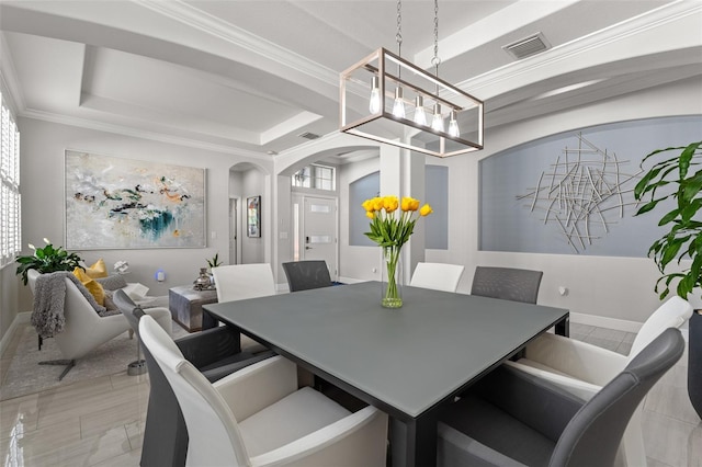 dining room featuring a notable chandelier, ornamental molding, and a tray ceiling