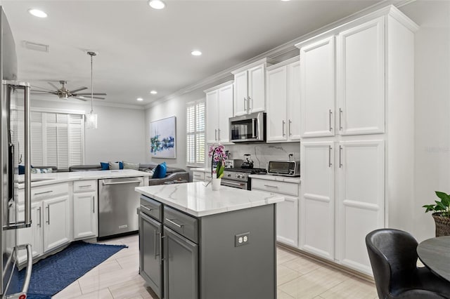 kitchen with gray cabinets, a center island, white cabinets, and appliances with stainless steel finishes