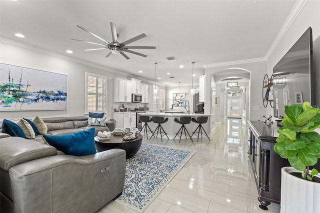 living room with ceiling fan and crown molding