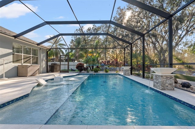 view of pool featuring a patio, pool water feature, and glass enclosure