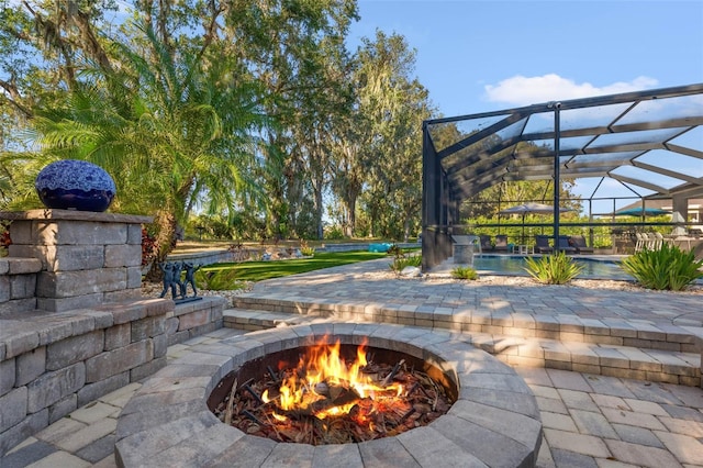 view of patio / terrace featuring a lanai and an outdoor fire pit