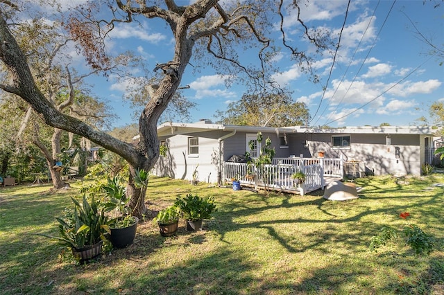 exterior space featuring a wooden deck and a lawn