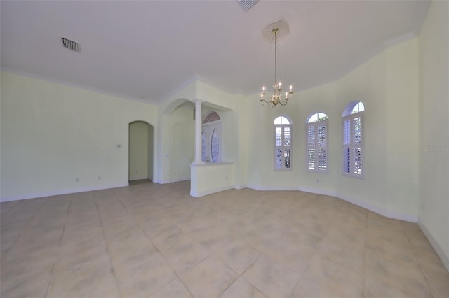 spare room featuring crown molding and a chandelier