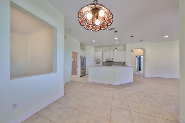 kitchen featuring white appliances, backsplash, hanging light fixtures, light tile patterned floors, and white cabinetry