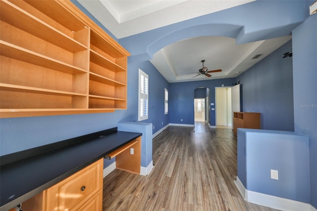 interior space featuring hardwood / wood-style floors, ceiling fan, and built in desk