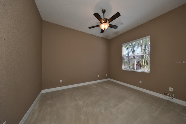 carpeted spare room with ceiling fan