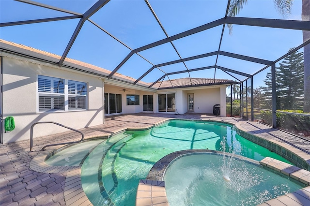 view of swimming pool featuring an in ground hot tub, glass enclosure, ceiling fan, and a patio area