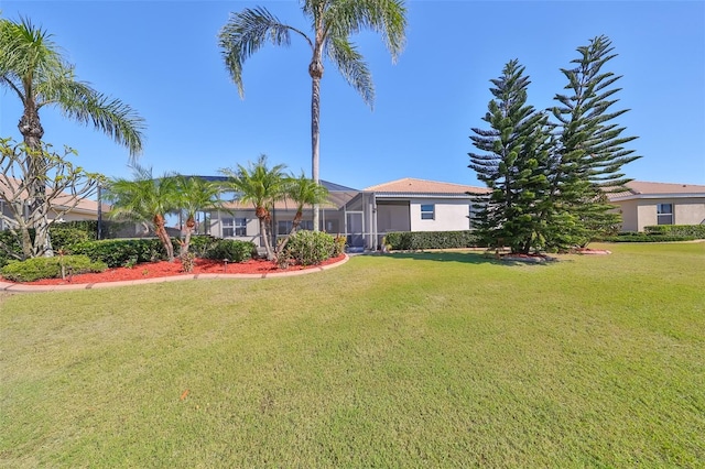 view of front of property with glass enclosure and a front lawn