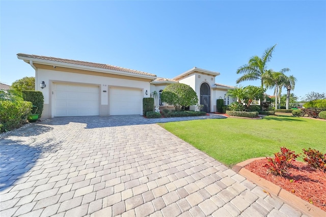 mediterranean / spanish house with a garage and a front lawn