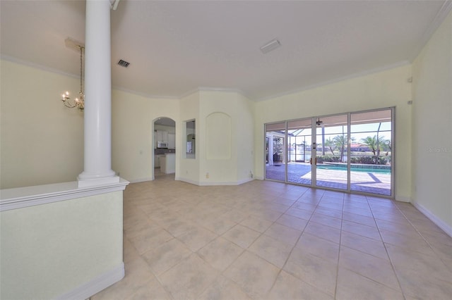 tiled spare room with decorative columns, crown molding, and a notable chandelier