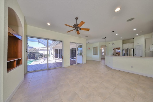 unfurnished living room with ceiling fan and light tile patterned floors