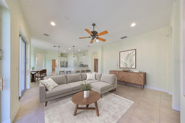 living room with ceiling fan and light tile patterned flooring