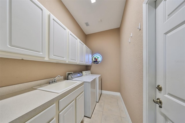 laundry room featuring light tile patterned flooring, cabinets, separate washer and dryer, and sink