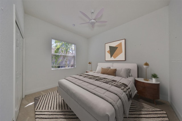 bedroom featuring light colored carpet, a closet, and ceiling fan